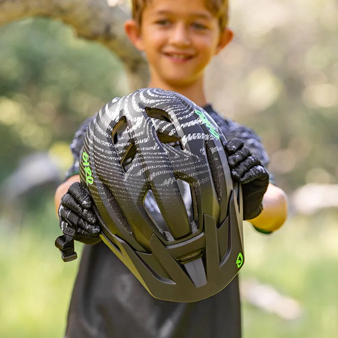 a small boy smiling while wearing the giro fixture II youth mips helmet