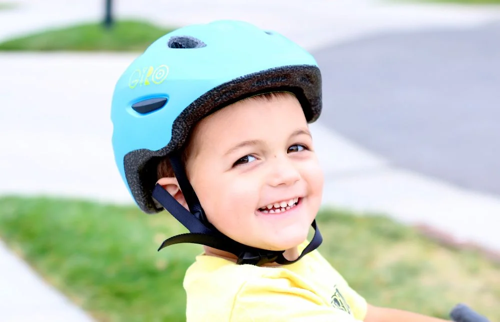 a small boy smiling while wearing the giro scamp helmet